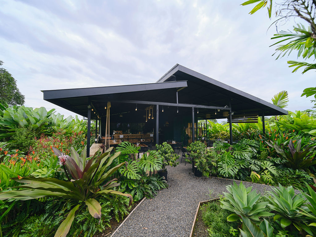 Open-air restaurant pavilion surrounded by tropical gardens