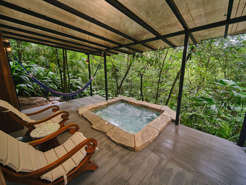 Private jacuzzi and sun loungers on the covered deck of the Bungalow Deluxe King
