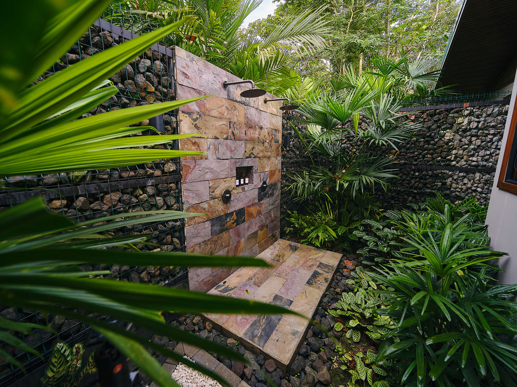 Stone garden shower of the Bungalow Luxury King among ferns and palms