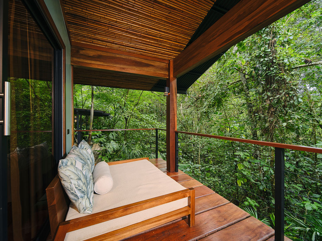 Daybed on the private deck of the Bungalow Deluxe King facing the forest