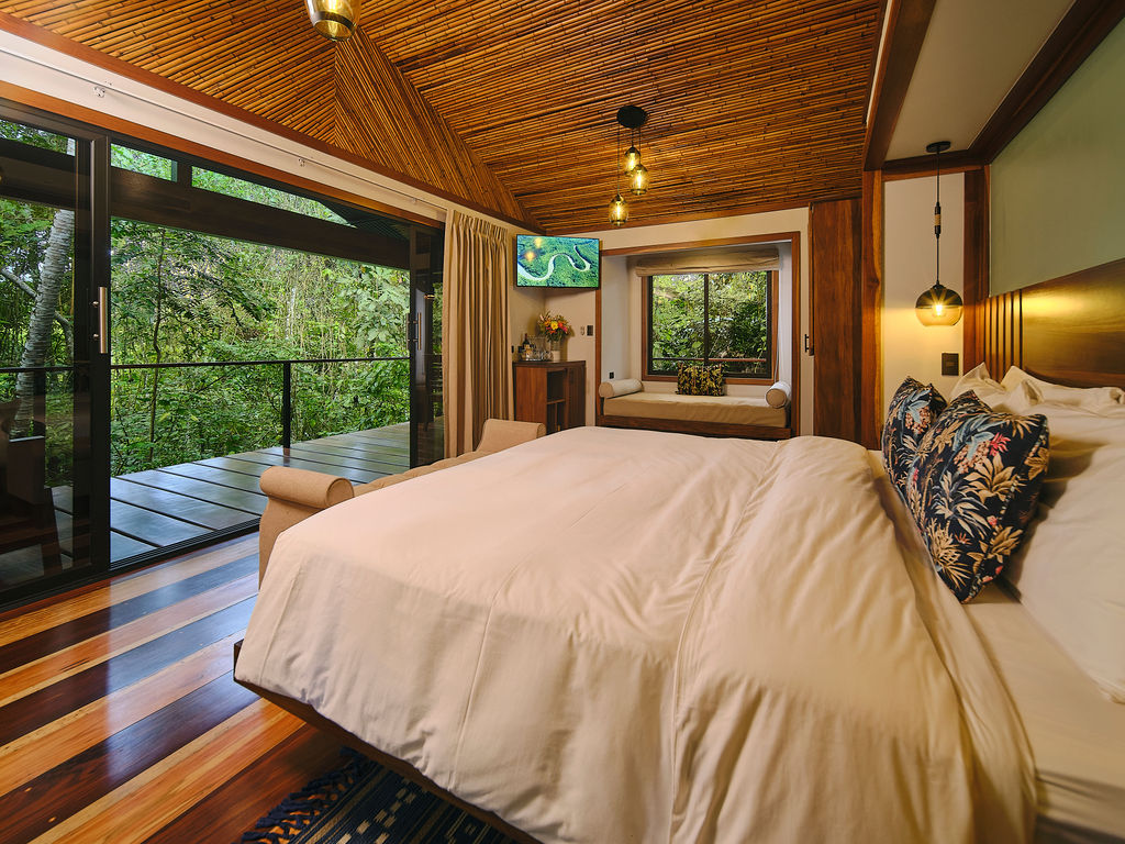 Bedroom opening onto the deck with the forest beyond